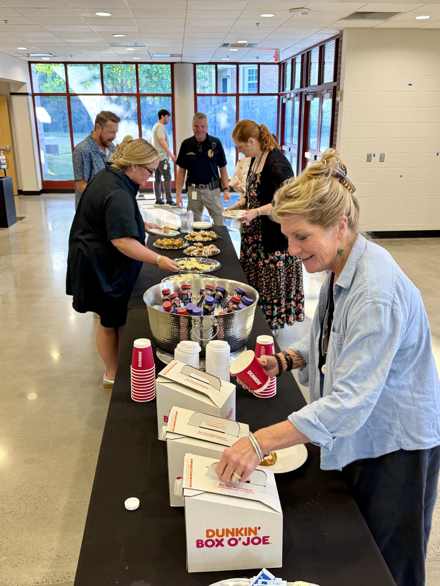 Parents and staff gathered around a table of refreshments at Harding